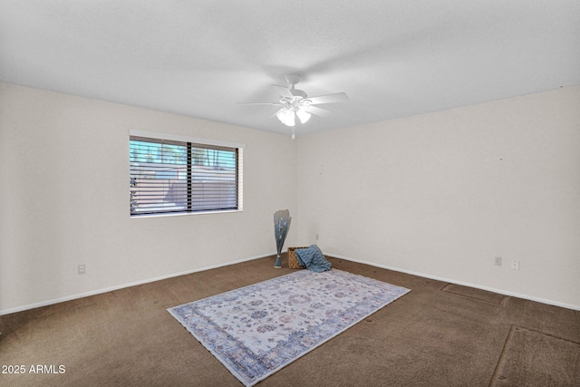 carpeted empty room with baseboards and a ceiling fan