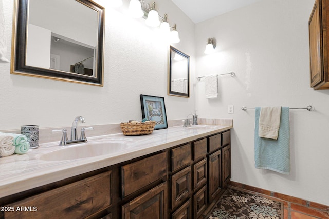 full bath with baseboards, double vanity, and a sink