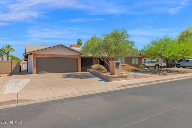 ranch-style house with concrete driveway, a gate, fence, and a garage
