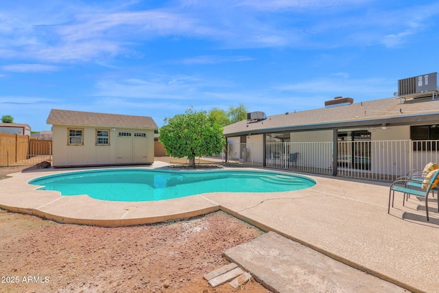 view of pool featuring a patio area, an outbuilding, a fenced backyard, a fenced in pool, and central AC unit