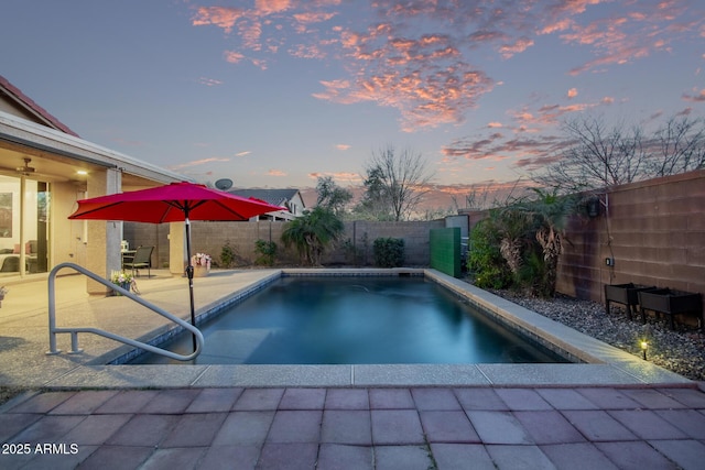 pool at dusk with a patio