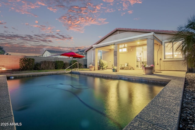 pool at dusk featuring a patio area