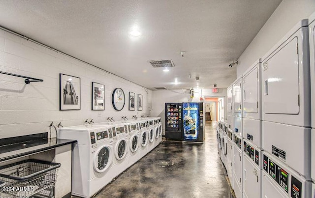 laundry room with independent washer and dryer, a textured ceiling, and stacked washer and clothes dryer