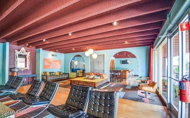 game room with beam ceiling and hardwood / wood-style floors