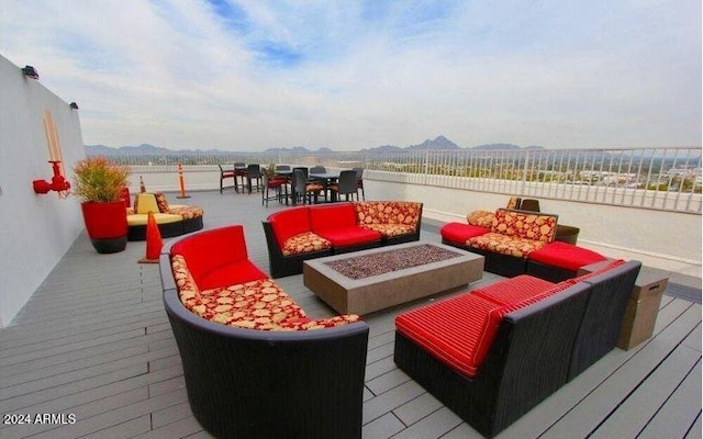 wooden terrace with an outdoor living space with a fire pit