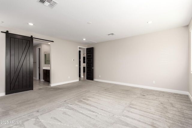 carpeted spare room with a barn door