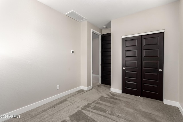 unfurnished bedroom with light carpet and a closet