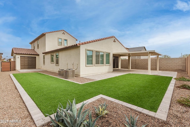 rear view of house featuring central AC, a yard, a patio area, and a garage