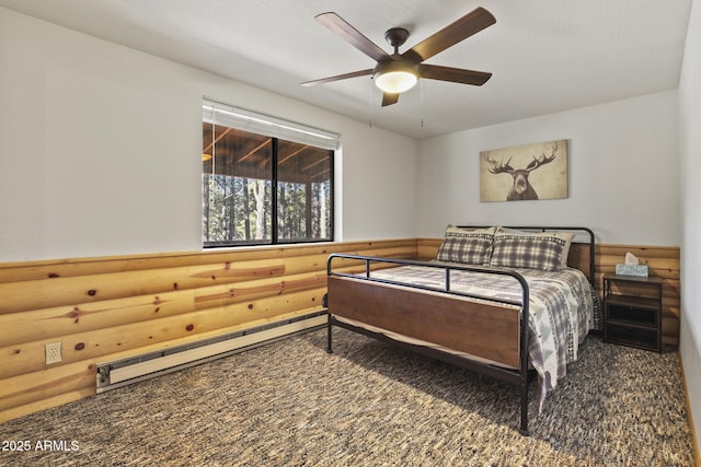 bedroom featuring baseboard heating, ceiling fan, and rustic walls