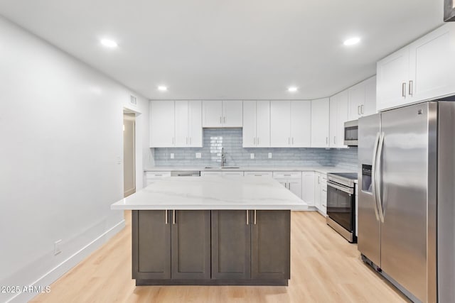 kitchen with white cabinetry, a center island, sink, and appliances with stainless steel finishes