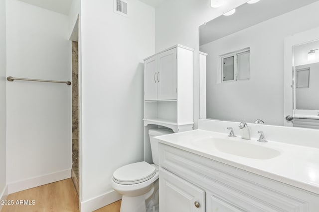 bathroom featuring vanity, hardwood / wood-style flooring, toilet, and walk in shower