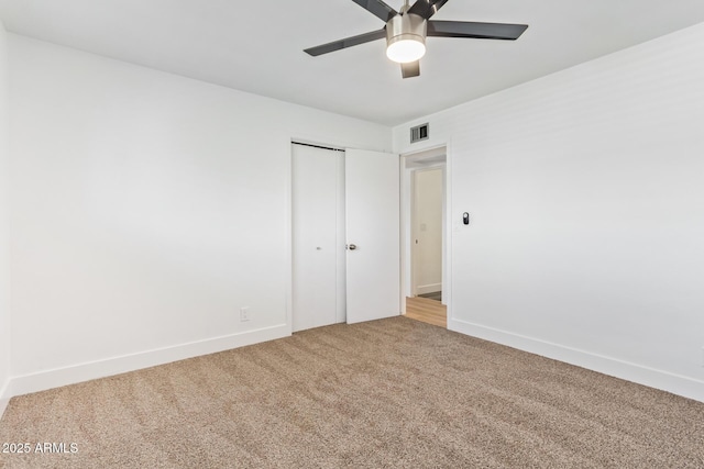 carpeted spare room with ceiling fan