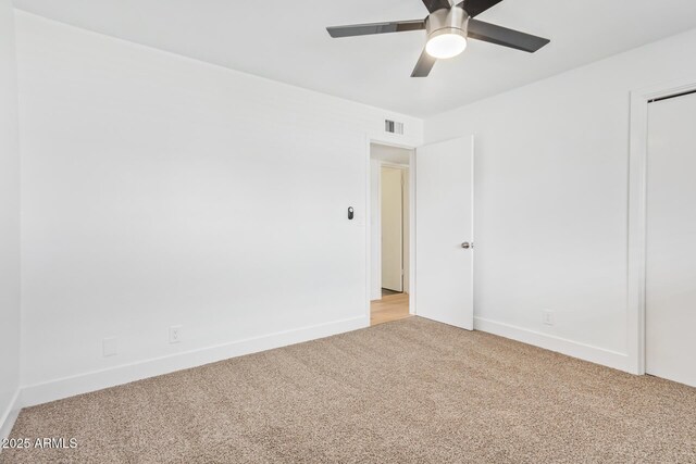 carpeted spare room featuring ceiling fan