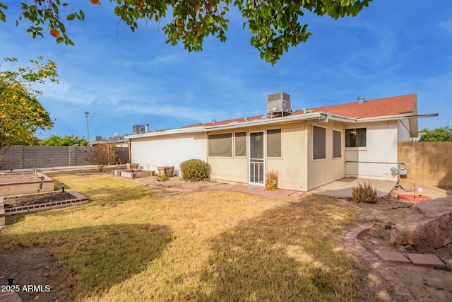 rear view of property with a lawn and central AC unit