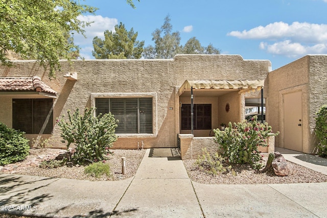 pueblo-style home featuring stucco siding