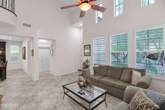 living room featuring ceiling fan and a towering ceiling