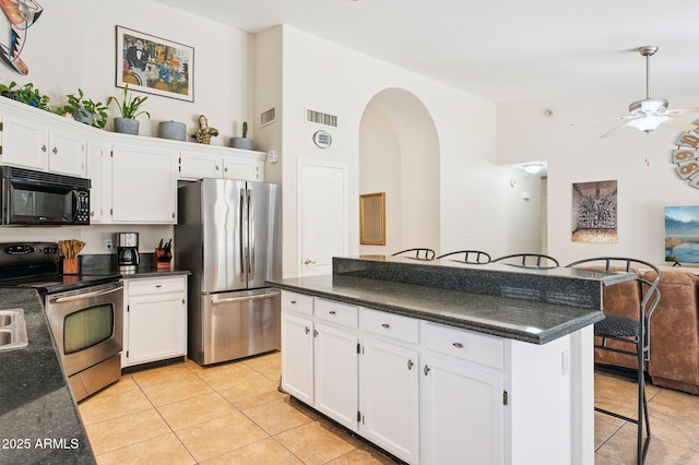 3133 E Redwood Ct, Phoenix, AZ 85048 - kitchen with stainless steel appliances, light tile patterned floors, dark countertops, and white cabinets