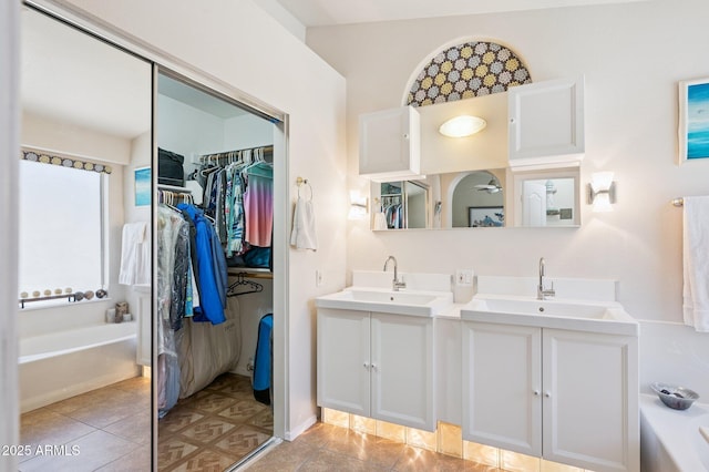 3133 E Redwood Ct, Phoenix, AZ 85048 - bathroom featuring a garden tub, double vanity, a spacious closet, and tile patterned floors