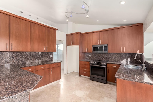 kitchen featuring vaulted ceiling, appliances with stainless steel finishes, tasteful backsplash, sink, and dark stone countertops