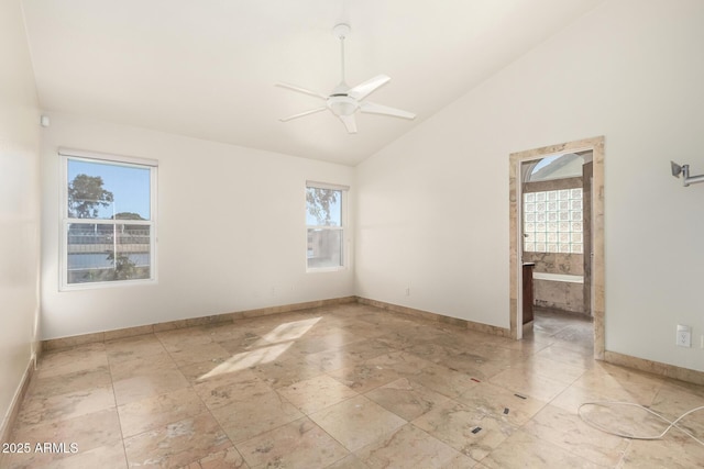 spare room with vaulted ceiling, ceiling fan, and plenty of natural light