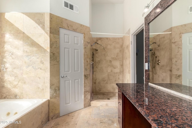 bathroom featuring vanity and independent shower and bath