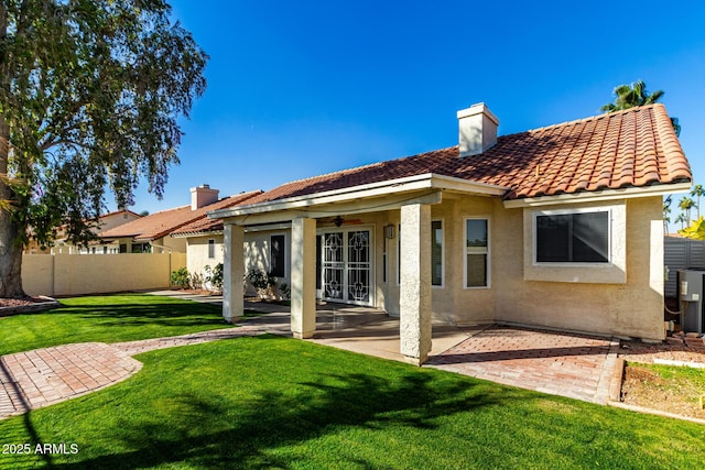 back of house with a patio, ceiling fan, and a lawn