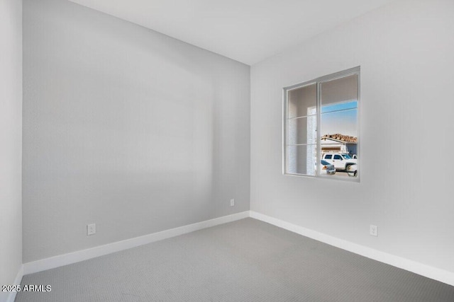 unfurnished room with baseboards and carpet flooring