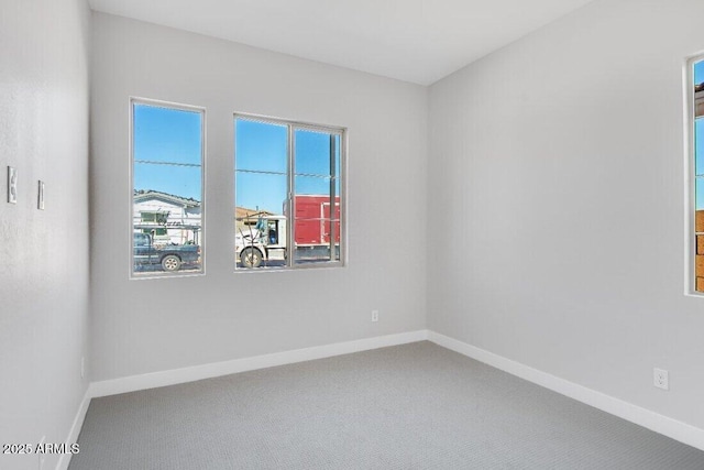 unfurnished room featuring baseboards and carpet floors