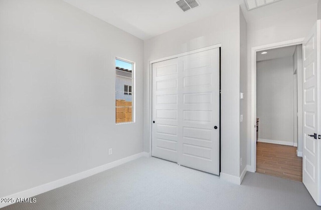 unfurnished bedroom featuring a closet, visible vents, baseboards, and carpet floors