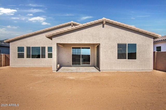 back of property with a patio area, stucco siding, a tiled roof, and fence