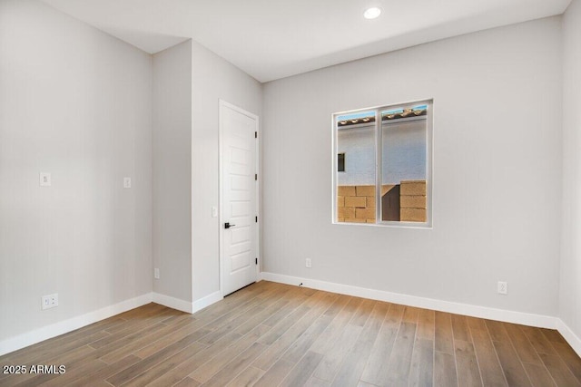 spare room featuring recessed lighting, baseboards, and wood finished floors