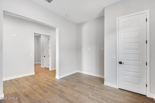 empty room with light wood-style floors and baseboards