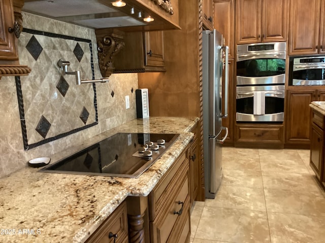 6540 E Wildcat Dr, Cave Creek, AZ 85331 - kitchen with stainless steel appliances, ventilation hood, backsplash, light stone counters, and brown cabinetry