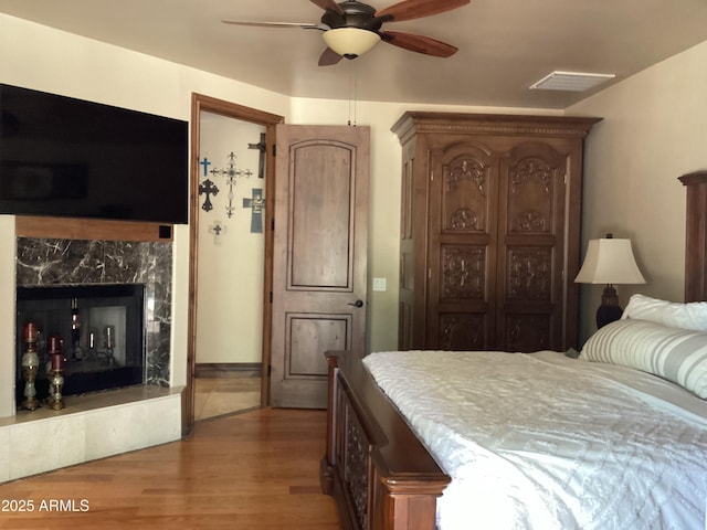 6540 E Wildcat Dr, Cave Creek, AZ 85331 - bedroom featuring wood finished floors, a fireplace, and ceiling fan