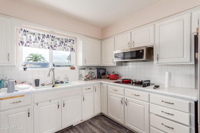 kitchen with white cabinetry, tile counters, black gas cooktop, and sink