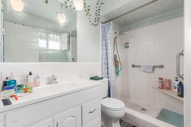 bathroom with vanity, toilet, curtained shower, and tile walls