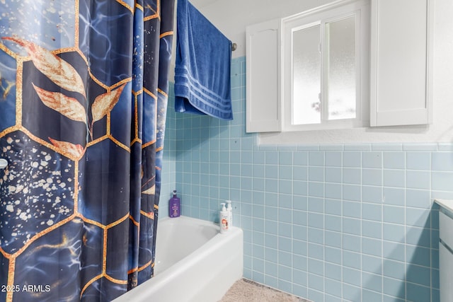 bathroom with tile walls and shower / tub combo with curtain