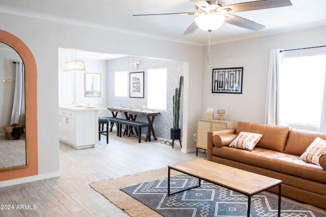 living room with light wood-type flooring, plenty of natural light, and ceiling fan