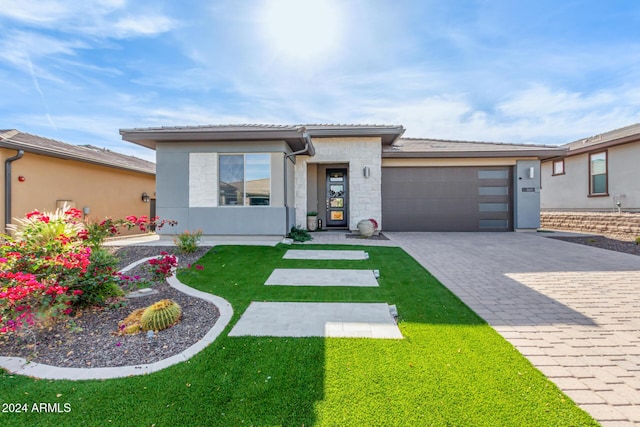 prairie-style home with a front yard and a garage