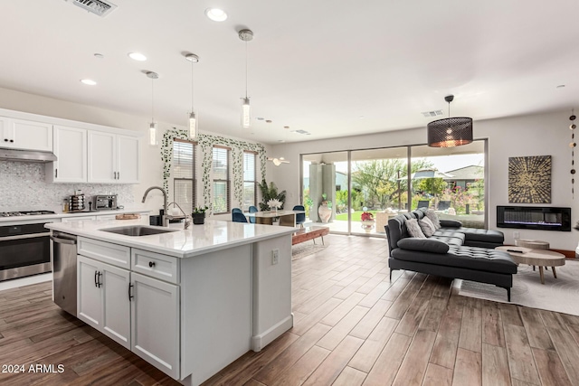 kitchen featuring pendant lighting, dark hardwood / wood-style flooring, white cabinetry, and sink