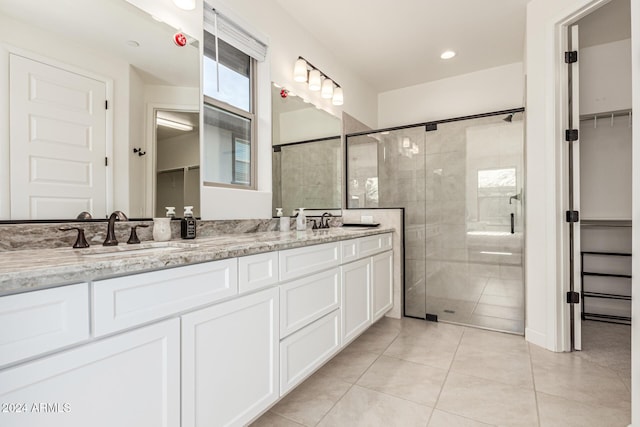 bathroom featuring tile patterned floors, vanity, and a shower with shower door