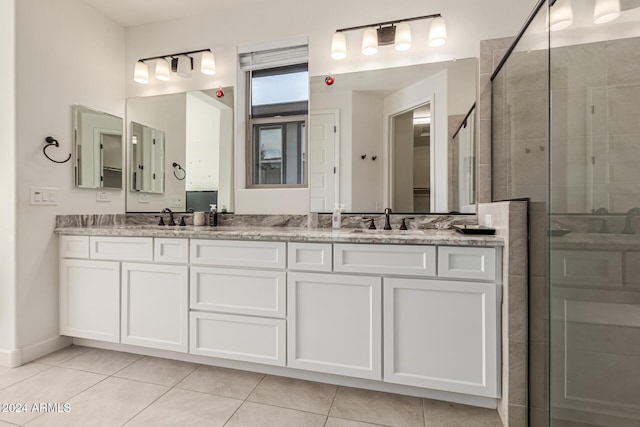 bathroom featuring tile patterned flooring, vanity, and a shower with door