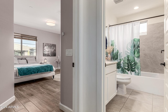 full bathroom featuring hardwood / wood-style flooring, vanity, toilet, and shower / tub combo