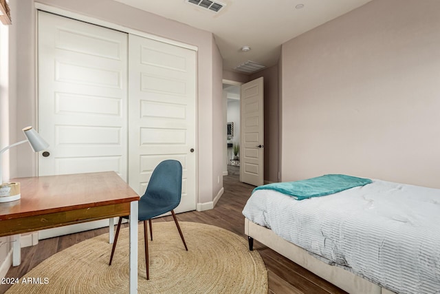 bedroom with dark hardwood / wood-style flooring and a closet