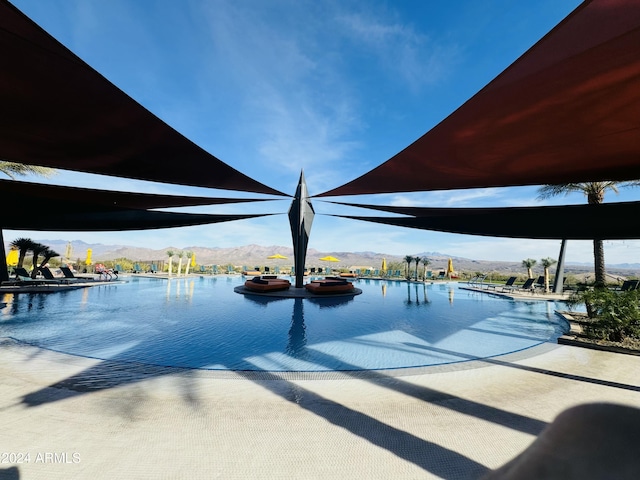 view of swimming pool with a water and mountain view