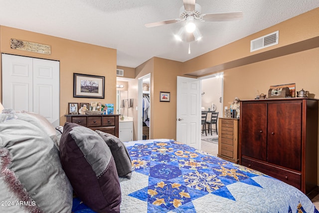 bedroom featuring ensuite bathroom, a textured ceiling, ceiling fan, and a closet