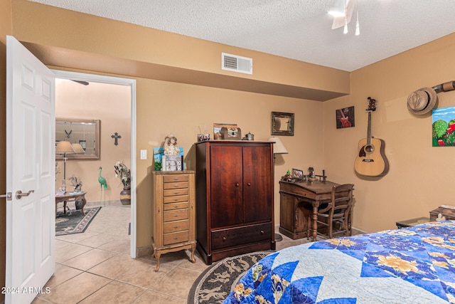 tiled bedroom with a textured ceiling and ceiling fan