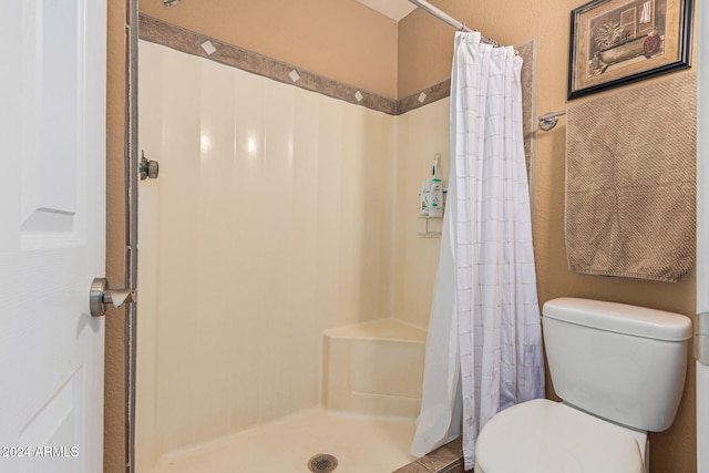 bathroom with a shower with curtain and toilet