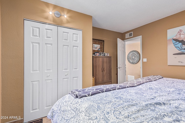 bedroom featuring a textured ceiling and a closet