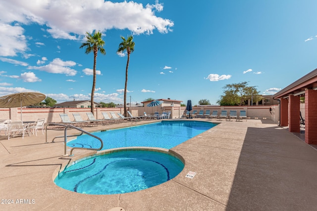 view of swimming pool featuring a community hot tub and a patio area